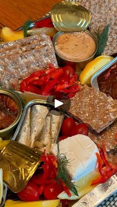 an assortment of food on a platter with cheese, tomatoes and other foodstuffs