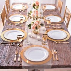 the table is set with gold and white plates