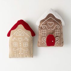 two small houses made out of fabric sitting next to each other on a white surface