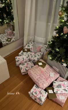 presents under the christmas tree are wrapped in pink and white paper