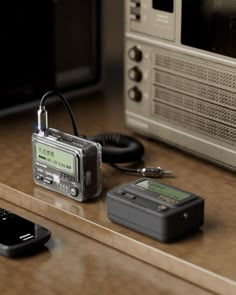 an electronic device sitting on top of a counter next to a phone and microwave oven