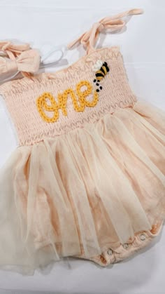 Beautiful one romper for your little babe. This listing is for a beige peach  romper, one lettering in off white and a bee appliqué next to it.  the sweetest bee ONE romper, perfect for you first bee-day celebration.  Birthday photoshoots, special events, etc. If you'd like a different color or saying, don't hesitate to contact us First Bee Day Photoshoot, Bee Themed One Year Birthday, Happy First Bee Day, First Birthday Honey Bee Theme, Bee One Birthday Party, First Birthday Themes Bee, First Birthday Bee Theme, Bee Day Party Ideas 1st, Bee Theme 1st Birthday