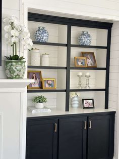 a black and white bookcase with pictures on it