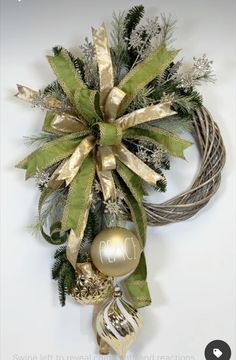 a christmas wreath hanging from the side of a wall with ornaments on it and an ornament