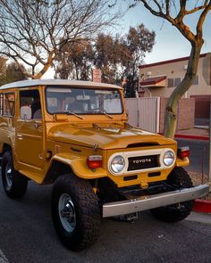 an old yellow toyota truck is parked on the street