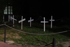 several crosses are placed in the grass at night