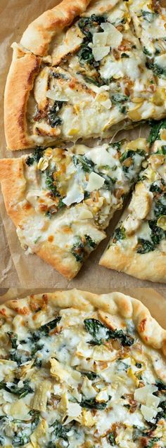 a pizza with cheese, spinach and other toppings cut into slices on a piece of parchment paper