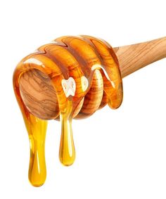 a wooden spoon with honey dripping from it