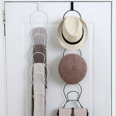 three hats and two purses are hanging on the front door hangers with hooks