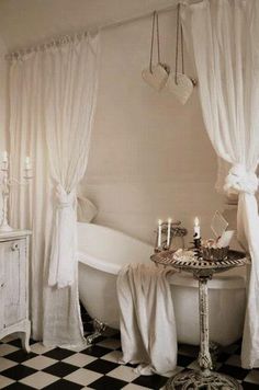 a white bath tub sitting next to a black and white checkered floor