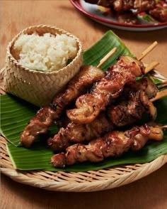 some food is sitting on a plate with rice and chopsticks next to it