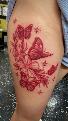 a woman's thigh with red butterflies on it