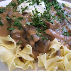 a white plate topped with pasta covered in mushroom gravy