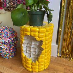 a potted plant sitting on top of a fake corn cob