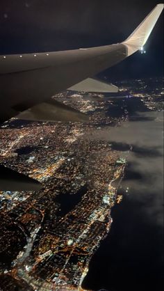 an airplane wing flying over the city lights