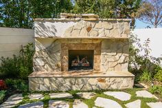 an outdoor fireplace in the middle of a garden