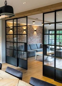 a living room filled with furniture next to a window covered in frosted glass doors