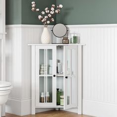 a white cabinet with glass doors in a bathroom