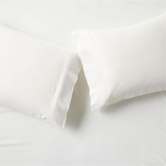 two white pillows sitting next to each other