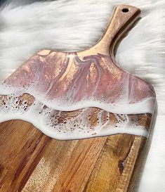 a wooden cutting board with soap on top of it and white fur in the background