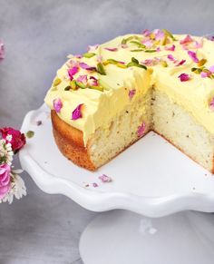 a white cake with yellow frosting and pink flowers on the top is cut in half