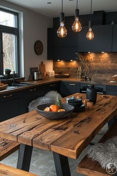 a wooden table sitting in the middle of a kitchen next to a window with lights hanging above it