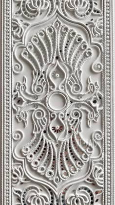 an intricately designed white paper with beading on it