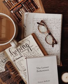 an open book sitting on top of a table next to a cup of coffee