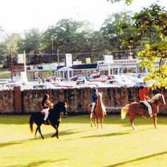 several people riding horses in an open field