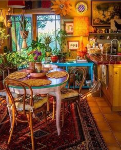 a dining room table and chairs with potted plants on top of them in front of a window