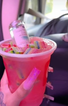 a person holding a pink cup filled with candy