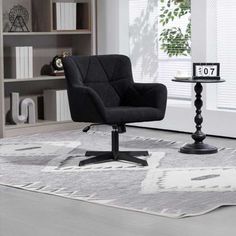 a black chair sitting on top of a white rug