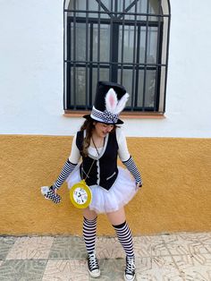 a woman dressed up as a rabbit with a clock in her hand and hat on