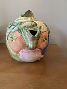 a ceramic vase sitting on top of a wooden table