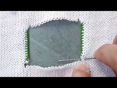 someone is stitching the edge of a piece of white fabric with green trims