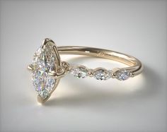 a pear shaped diamond engagement ring on a white background