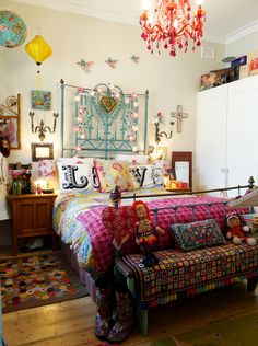 a room with a bed, couch and chandelier hanging from it's ceiling