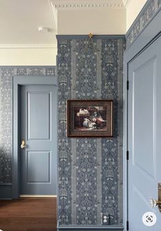 an empty hallway with blue doors and wallpaper