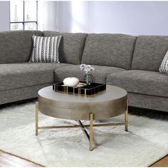 a living room with grey couches and white rugs