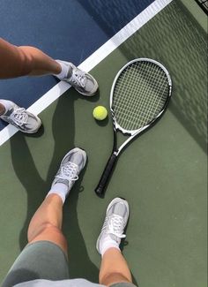 a person standing on a tennis court holding a racquet next to a ball