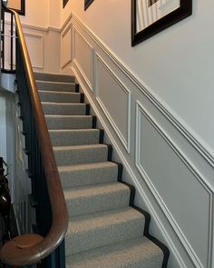 the stairs are lined with carpet and framed pictures