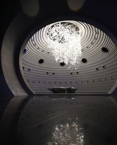 an artistic sculpture is shown in the middle of a reflective surface with light coming from it