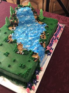 a cake that is shaped like a pond with horses on the water and stars around it