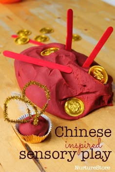 an object made out of red paper with gold coins on it and the words chinese inspired sensory play