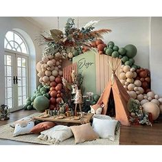 a room filled with lots of balloons and decorations on the wall, including a teepee tent