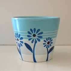 a blue and white flower pot sitting on top of a counter next to a wall