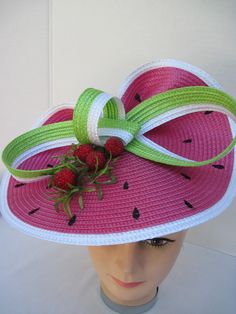 "* This design features the watermelon braiding as the hat foundation folded into design loops complemented by red raspberries and summer greens. * The hat form is about 12\" folded in back and tilted in a sophisticated design. * It is light weight, balanced and comfortable to wear year round. * Designed on a satin covered metal headband, it fits just about any head size and when viewed from any direction it looks complete, striking and eye catching. * Wear it throughout the year for special eve Pink Adjustable Hat Bands For Summer, Fun Green Sun Hat For Summer, Adjustable Red Hat Bands For Summer, Green Summer Boater Hat With Flat Brim, Green Boater Hat With Flat Brim For Summer, Green Flat Brim Boater Hat For Summer, Adjustable Red Hat Bands For Spring, Green Boater Hat With Curved Brim For Summer, Green Brimmed Boater Hat For Summer