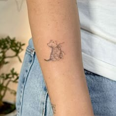 a woman's arm with a small tattoo of a cat on the left wrist