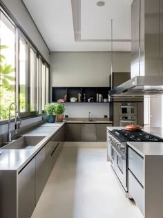 a modern kitchen with stainless steel appliances and large windows