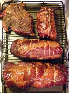 four different types of meats are on a grill with some string wrapped around them